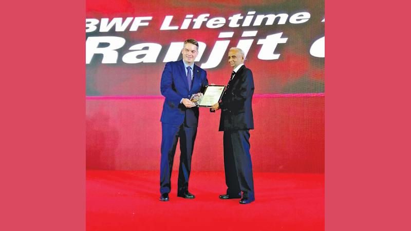 Professor Ranjit Silva (right) receiving his award from the president of the BWF Paul Eric Larsen