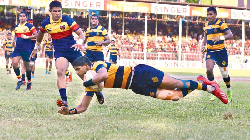 Royal College centre Lehan Gunaratne flies over the line to score a try in their Bradby Shield rugby match against Trinity College at Pallekele yesterday (Picture by Sulochana Gamage)    