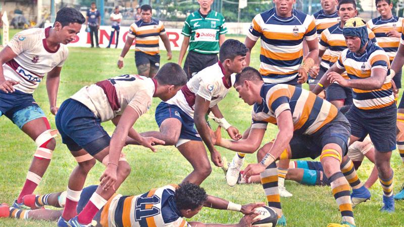 St. Peter’s College winger Shenol Silva secures the ball against the forwards of Science College in their inter-school League rugby match at Bambalapitiya yesterday. (Picture by Thilak Perera)    