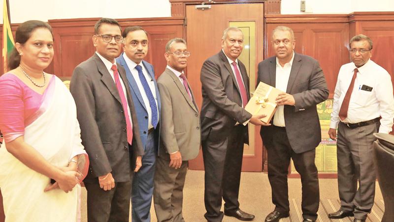 NSB Chairman Jayaraja Chandrasekera presents the Annual Report to Minister of Finance Mangala Samaraweera.Senior Deputy General Manager, NSB, J.K. Gamanayake, Deputy General Manager, Research and Development, K. Raveendran, Deputy General Manager, Finance and Planning, Kithsiri B. Wijeyaratne and Secretary to the Board of Directors, M.A.P. Muhandiram look on.