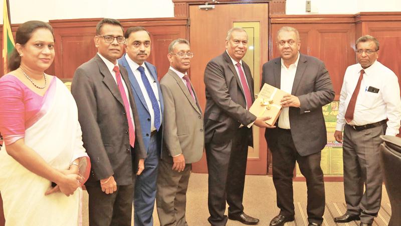 NSB Chairman Jayaraja Chandrasekera presents the Annual Report to Minister of Finance Mangala Samaraweera.Senior Deputy General Manager, NSB, J.K. Gamanayake, Deputy General Manager, Research and Development, K. Raveendran, Deputy General Manager, Finance and Planning, Kithsiri B. Wijeyaratne and Secretary to the Board of Directors, M.A.P. Muhandiram look on.   