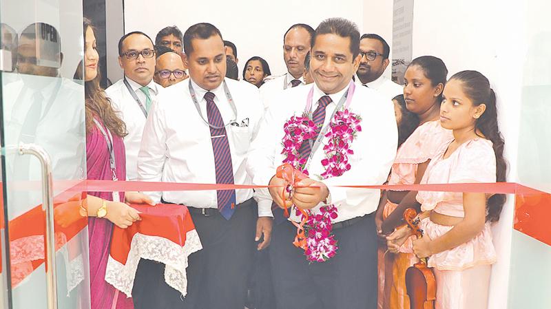 Director/CEO of Seylan Bank, Kapila Ariyaratne opens the branch. Bank officials look on.