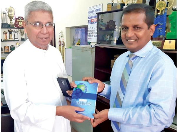  Ajith Perera, the author of the book  hands over the first copy to Rev.  Bro. Placidus Fernando FSC.   