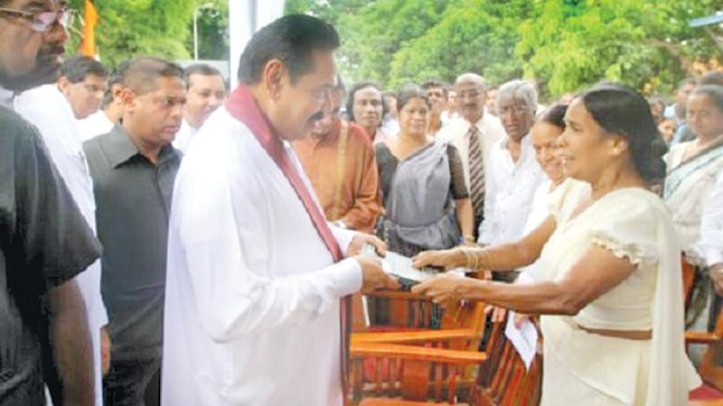 Nirmala presents her book Premakeerthi to a startled President Rajapaksa saying“The killer of my husband is under your protection.”   