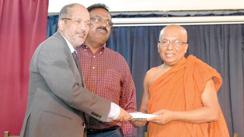 Author Lukman Harees presents the first copy of the book, ‘Wisdom at our Doorstep’ to Ven. Galkande Dhammananda Thera  