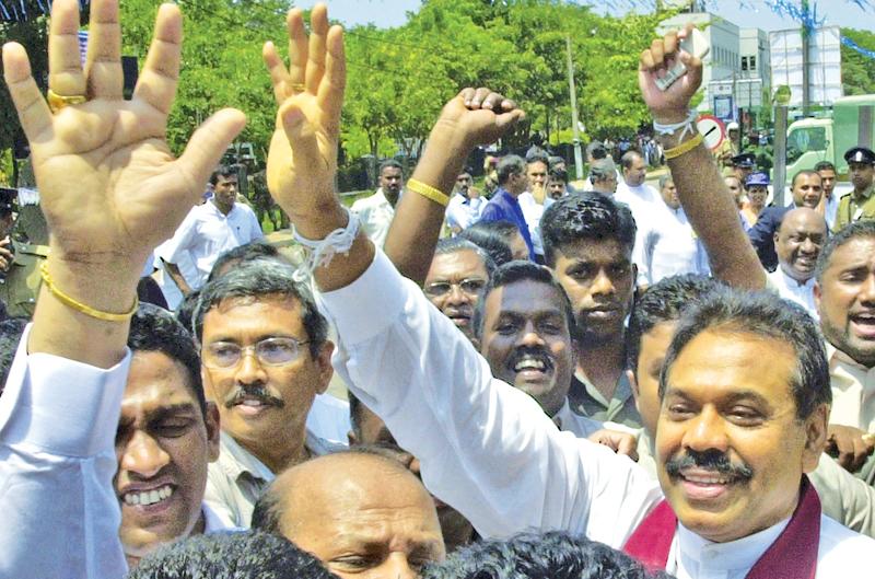 COLOMBO, SRI LANKA: Sri Lankan Prime Minister Mahinda Rajapakse (R) waves to crowds 07 October 2005 in Colombo shortly after filing his nomination papers to contest the 17 November 2005 presidential elections. Thirteen candidates entered the fray, but the contest is seen largely as a battle between Rajapakse and his main challenger, opposition leader Ranil Wickremesinghe. AFP PHOTO/Lakruwan Wanniarachchi