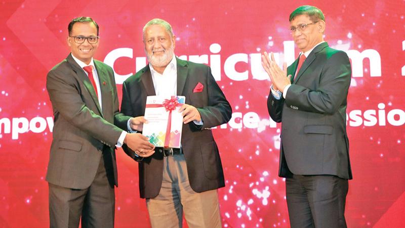 Chairman of the Curriculum Task Force, Chaaminda Kumarasiri presents the first copy of the Curriculum 2020 to chief guest Rajendra Theagarajah. CA Sri Lanka President Jagath Perera looks on. 