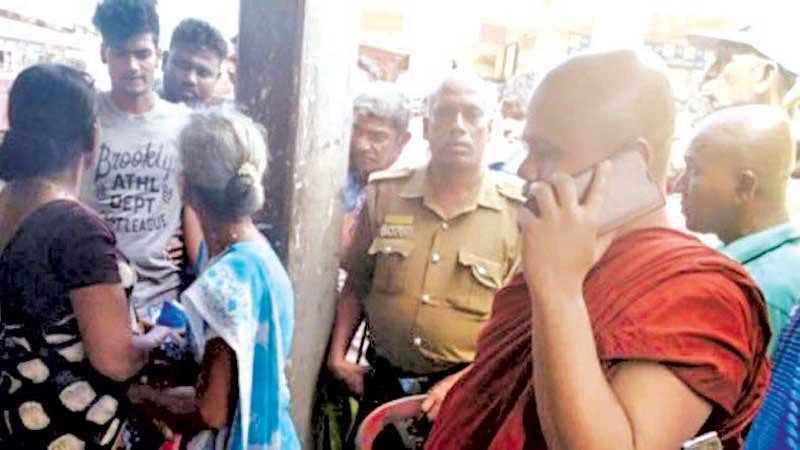 The Tamil woman is seen here surrounded by an angry mob led by a Buddhist monk