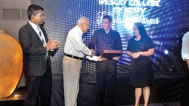 Roshan Mahanama flanked by his wife Jeeva is presented with a memento from former Wesley College principal MAP Fernando  