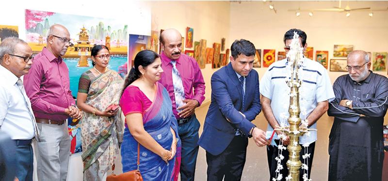 Dr. Revant Vikram Singh, director of the Indian Cultural Centre ceremonially opening the exhibition by lighting the oil lamp. Dr. Monica Sharma, the Hindi language professor at the Cultural Centre, Artist R. Kouwshigan, Mrs. Kowshigan, Chairman of the Colombo Saibaba Centre S. Udhayanayagam, Deputy Chairman Siva Rajajothy, Literary Philosopher Hasim Omar, and Author Memon Kavi are also seen.