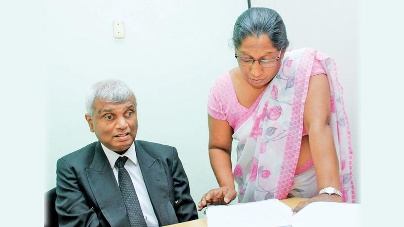  Kanthi Swarnalatha reads out a document aloud to Udayasiri Rajapaksa.             Pic : Roshan Pitipana