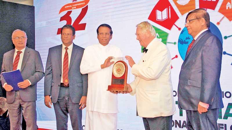 President Maithripala Sirisena presents a token of appreciation to guest of honour former Deputy Speaker, House of Commons, Lord Naseby. Pix: Wimal Karunathilake 