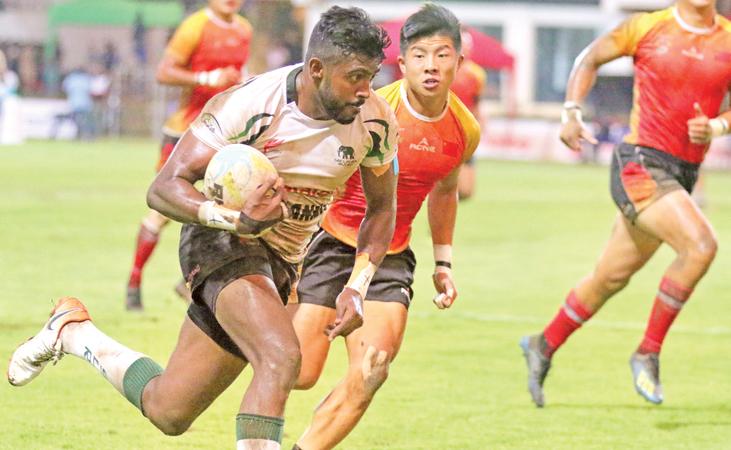 Sri Lanka Sevens captain Dansha Dayan beats the Chinese defence in their Asian rugby series match at the Race Course ground in Colombo last Sunday  (Pic by Saman Sri Wedage)    