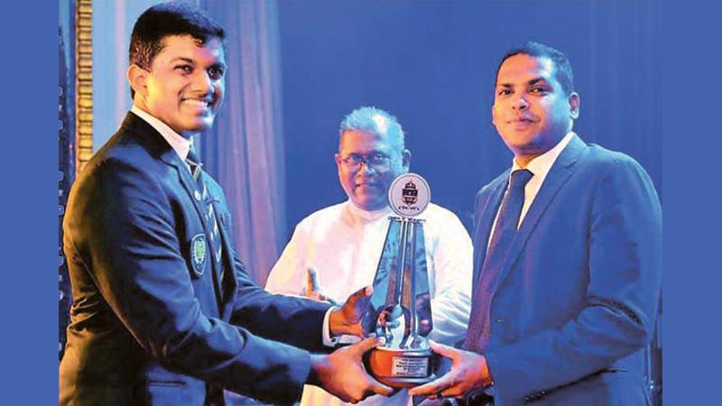 Sports Minister Harin Fernando presenting the Outstanding Sportsman of the Year award to Randev Athukorala at the Colours Night of St. Peter’s College in the presence of former Rector Rev. Fr. Trevor Martin  