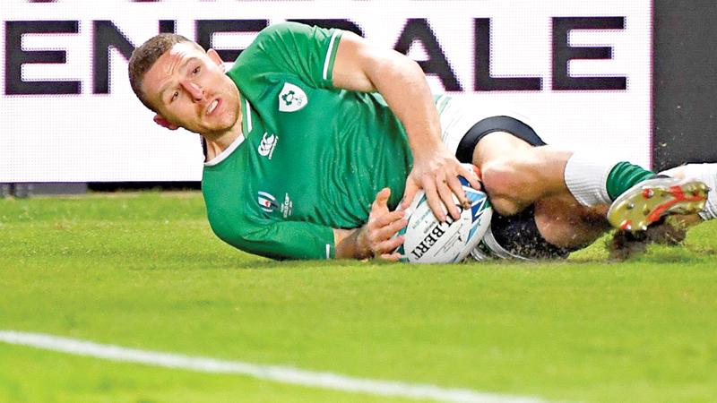 Ireland’s wing Andrew Conway scores a try during their Rugby World Cup match against Samoa in Fukuoka yesterday (AFP)