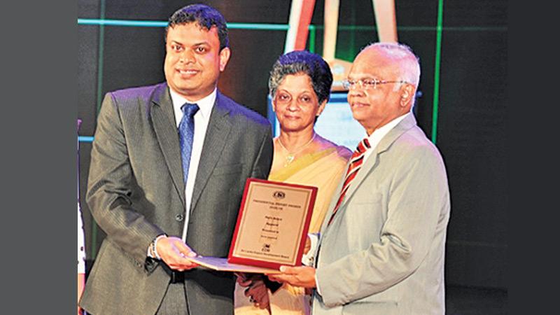 Sirio Production Manager Duminda Sasanapala (second from left)  receives the award from Justice D. J. de S. Balapatabendi. EDB  Chairperson and CEO Indira Malwatte  looks on.