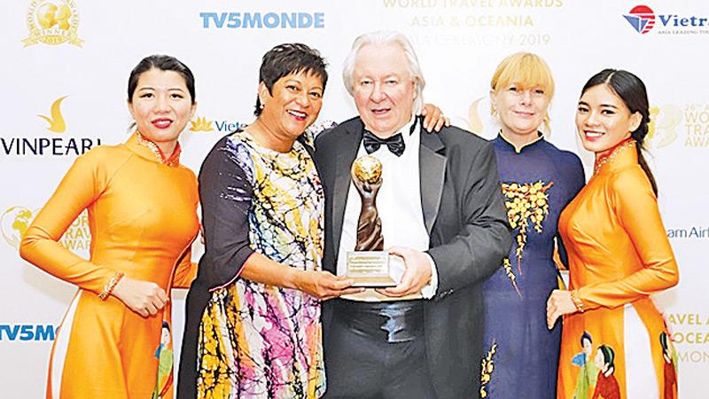 WTA President Graham Cooke (centre) presenting the award to Ravini Perera, Partner at Sri Sharavi Beach Villas & Spa. Also present is General Manager Marcy Vale (second from right)    