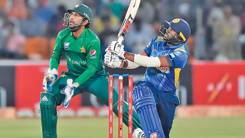 Bhanuka Rajapaksa smashes a six watched by Pakistan wicket-keeper Sarfaraz Ahamed in the recent T20 series