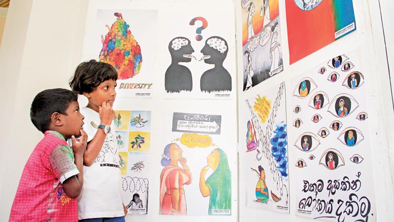Children are left high and dry in the absence of the breadwinner. Here children taking a look at some of the paintings on families of missing persons are in deep thought over the tragedy that befell them. Pic: Sudam Gunasinghe 