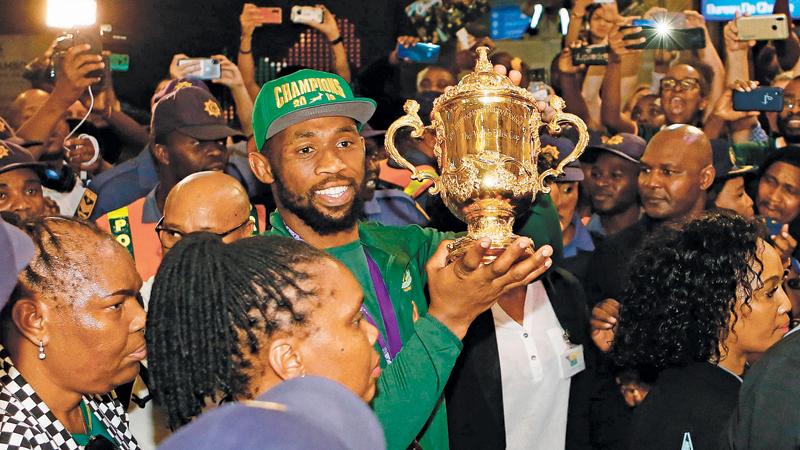 South Africa rugby captain Siya Kolisi carries the Web Ellis World Cup through the crowd upon the team’s arrival in Johannesburg (AFP)