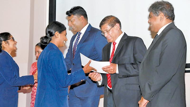 CA Sri Lanka President Jagath Perera presents a scholarship to a student of Musaeus College.