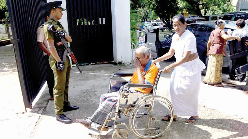 An elderly voter being wheeled into a polling station during  yesterday’s (November 16) Presidential election.   (Pic by Sulochana  Gamage)