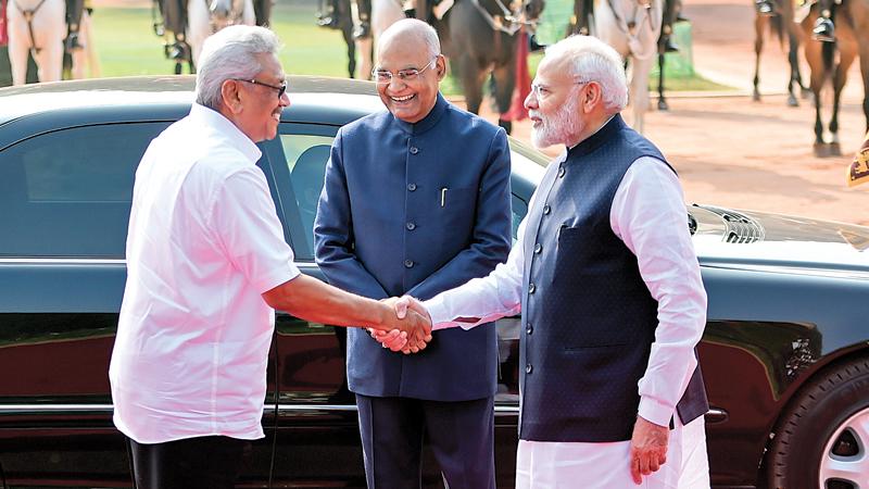 President Rajapaksa (L) shakes hands with India’s Prime Minister Modi (R) as India’s President Ram Nath Kovind looks on during a ceremonial reception