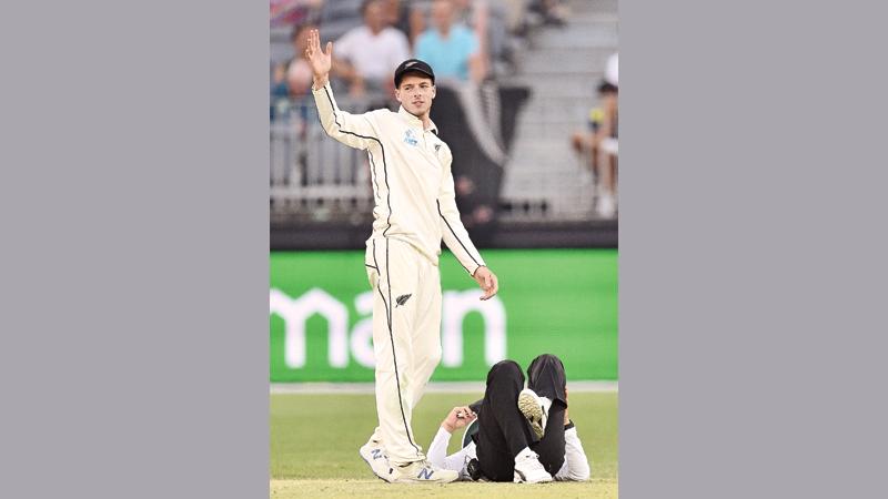 New Zealand’s Mitchell Santner calls for assistance for Pakistani cricket umpire Aleem Dar after knocking him over on day three of the first Test against Australia (AFP)