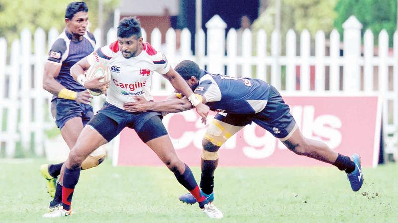 Kandy SC full back Dansha Dayan fends off a tackle from a Police defender in their League rugby match at Police Park in Colombo yesterday (Pic by Shan Rambukwella)