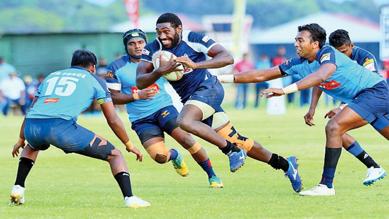 Police Centre Emoci Vunivosa makes a break hotly pursued by two Air Force defenders in their Dialog ‘A’ Division League Rugby match played at Ratmalana yesterday which Police won 36 – 15. Picture by Saman Sri Wedage 