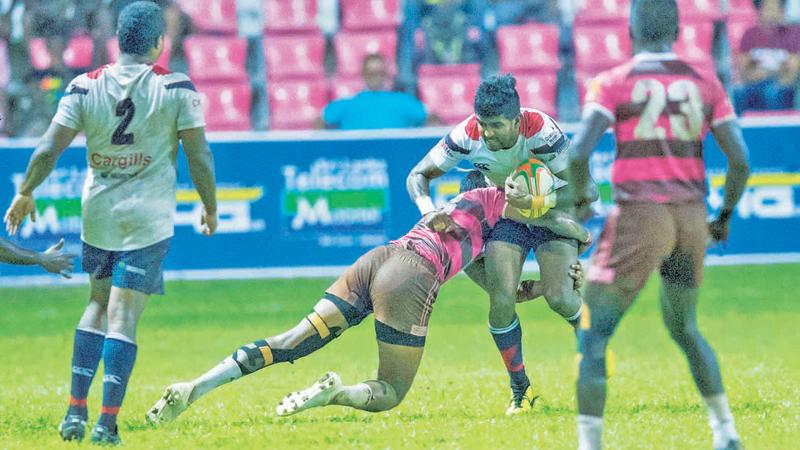 Kandy SC player Dansha Dayan is held by a Havelocks defender’ Pic by Shan Rambukwella