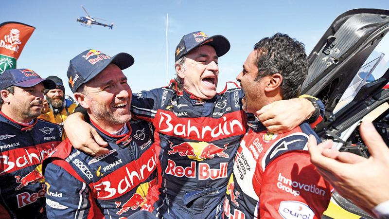 First-placed for the auto category JCW X-RAID Team Spain’s driver Carlos Sainz (C), celebrates as he is congratulated by second-placed Toyota’s team Qatar’s driver Nasser Al-Attiyah (R) and by third-placed JCW X-RAID Team France’s Stephane Peterhansel on the finish area in Qiddiya at the end of the stage 12 of the Dakar 2020 between Haradh and Qiddiya, Saudi Arabia, on January 17, 2020. (Photo by FRANCK FIFE / AFP)