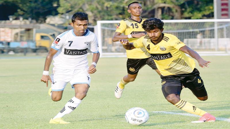 Saunders player MHE Chameera (right) competes for the ball against Air Force opponent LKN Ishan as his Saunders team-mate Chamatha Rashimitha races in for support play in their Vantage FA Cup semi final at the Race Course ground yesterday. Saunders won 5-1                                                             (Pic Shan Rambukwella)    