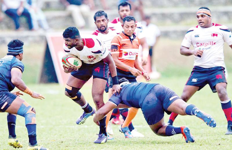 Kandy SC’s Soyuru Anthony attempts to break away from a Navy tackle (Pix Shan Rambukwella)