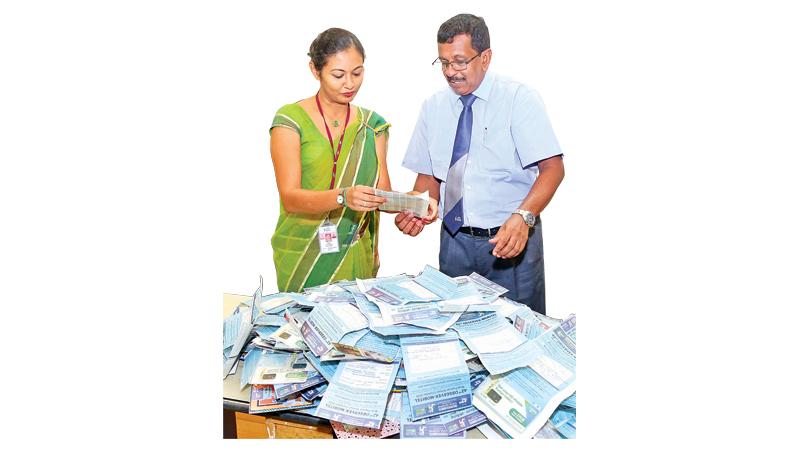 Senior Deputy General Manager D. Kamal Wijesuriya and Senior Executive (IT) Dinusha Jayalath picking the Observer Mobitel School Cricketer Readers’ Coupon No. 6 draw at ANCL editorial  (Picture by Shan Rambukwella)     
