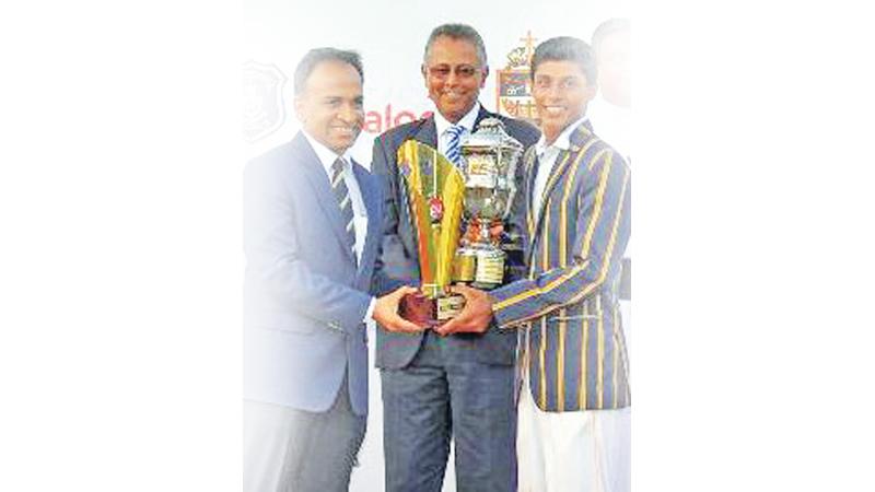 Danal Hemananda (right) of St. Peter’s College receives the best allrounder’s trophy from Munesh David the vice president of Dialog Axiata at the conclusion of the drawn Battle of the Saints big match cricket encounter against St. Joseph’s College at the P Sara Oval in Colombo yesterday    