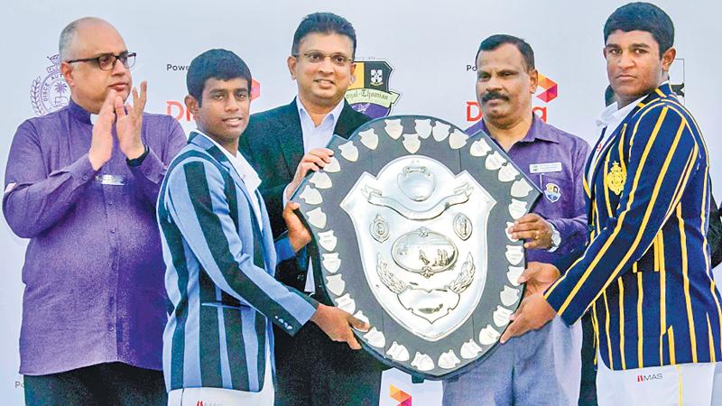 Thevin Eriyagama the captain of S. Thomas’ College (left) and Thevindu Senaratne the captain of Royal College hold the DS Senanayake Shield that was presented by Supun Weerasinghe the Group Chief Executive Officer of Dialog Axiata after their 141st big match ended in a draw at the SSC ground yesterday in the presence of Rev. Marc Billimoria (left) warden of S. Thomas’ College and BA Abeyratne the principal of Royal College