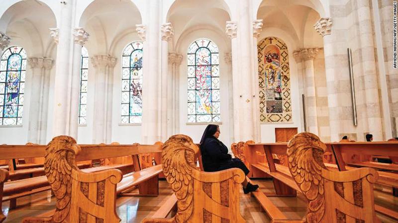 A nun sits among empty pews at the Good Friday celebration at the Mother Teresa cathedral in Pristina, Kosovo on Good Friday.