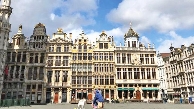 One man and his dog are the only visitors in a normally busy Grand Place in central Brussels