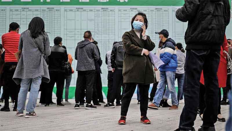 A job applicant makes a call at an on-site job fair in Wuhan last month. The landscape for job hunters might get even more difficult in the coming weeks as about 8.7 million people graduate from colleges and universities.