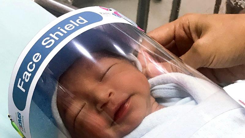A newborn baby wearing tiny face shields made to protect from Covid-19 at Paolo Hospital Samutprakarn in central Thailand.