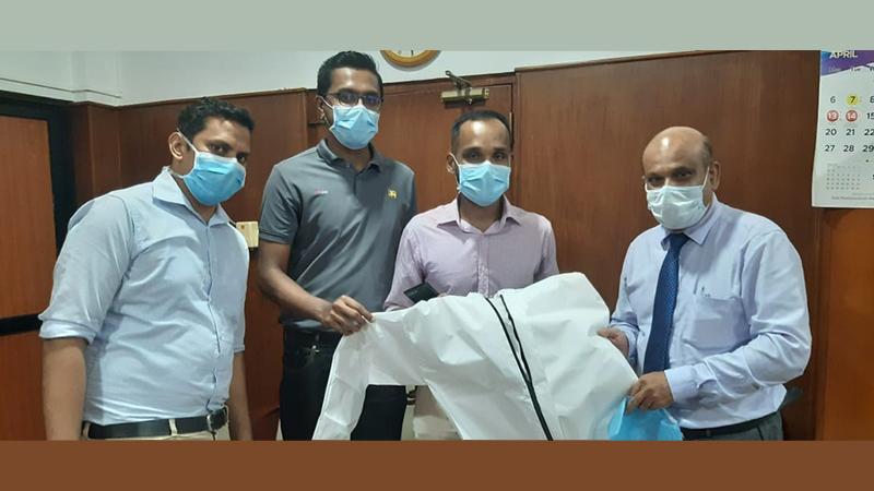Officials of MAS Holdings present non-woven disposable coverall PPE to the Additional Secretary, Ministry of Health, Dr. Sunil de Alwis