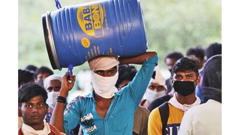 Migrant workers along with their family members walk on a road as they return to their villages during an extended nationwide lockdown to limit the spreading of the coronavirus pandemic in New Delhi