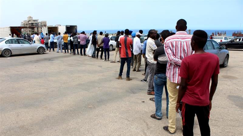Migrants in Tripoli, the capital of Libya, queue to receive food packages distributed by the United Nations High Commissioner for Refugees following the coronavirus outbreak