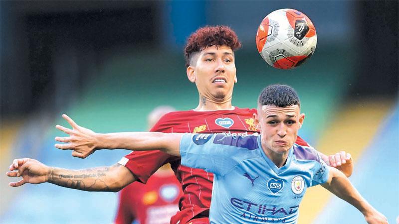 Liverpool's Brazilian midfielder Roberto Firmino (L) vies with Manchester City's English midfielder Phil Foden (R) during the English Premier League football match on July 2, 2020. ( AFP)