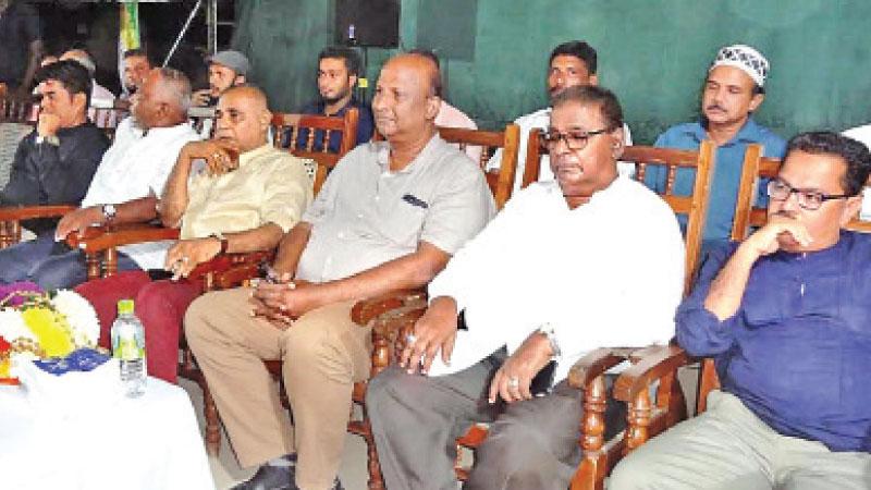 A.L.M. Athaullah on stage with supporters.