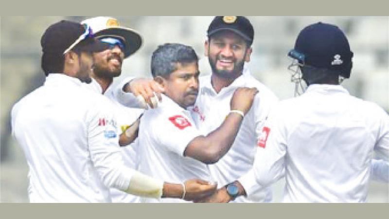 File photo of Sri Lanka cricketers Dhananjaya de Silva, Dinesh Chandimal, Rangana Herath and  Dimuth Karunaratne celebrating an occasion against Bangladesh the last time the two countries played a Test series    