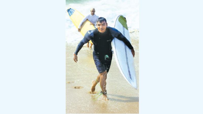 Sports Minister Namal Rajapaksa comes ashore after surfing the waves in sunny Hambantota (Pic by Sulochana Gamage)    