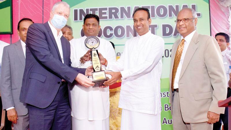 State Minister of Plantations, Arundhika Fernando and Minister of Plantations, Dr. Ramesh Pathirana present the award to Nestlé’s Managing Director Fabrice Cavallin. Chairman of the Coconut Development Authority, the Coconut Cultivation Board and the Coconut Research Institute, Jayantha Wickramasinghe looks on.