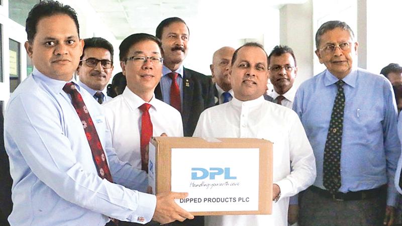 DPL Deputy Managing Director, Pushpika Janadheera presents a box of gloves to Minister of Environment, Mahinda Amaraweera at the Central Environmental Authority.